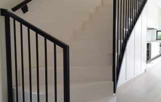 L-trappa i massiv furu, vitmålad och stål svartmålad räcke.